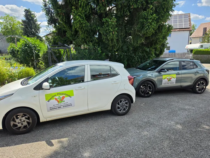 Zwei Fahrzeuge der Münchner Pflegedrachen mit Logo, geparkt vor dem Büro in München-Aubing